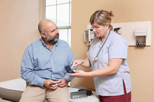 Man with diabetes at doctor office talking to health care provider.