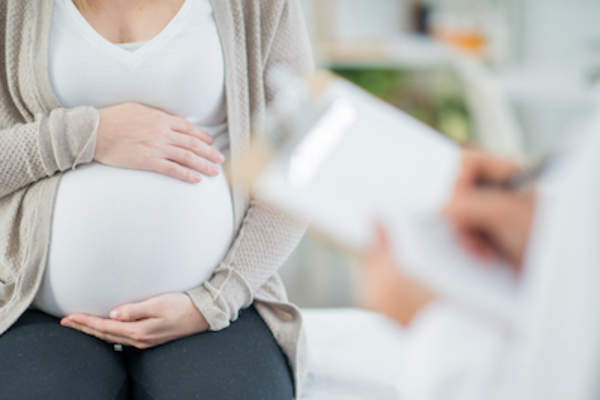 Pregnant woman talking to doctor.