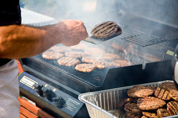 Person Flipping Burgers During BBQ
