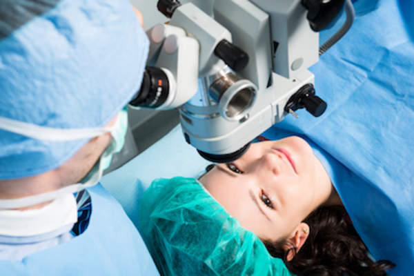 Surgeon setting up equipment for eye surgery.