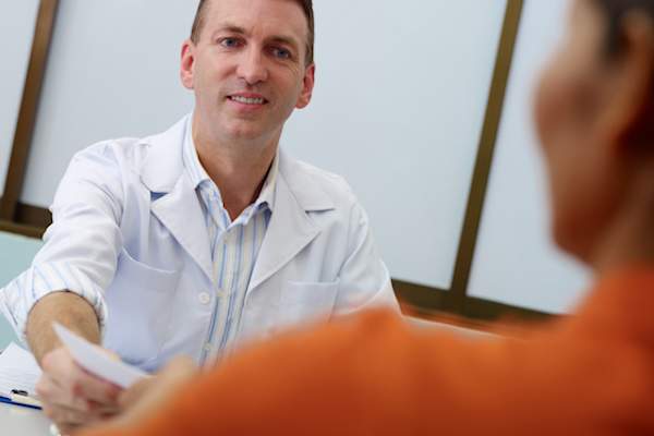 Doctor giving prescription to man.