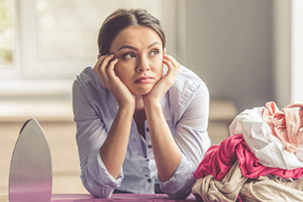 Woman bored of ironing clothing.