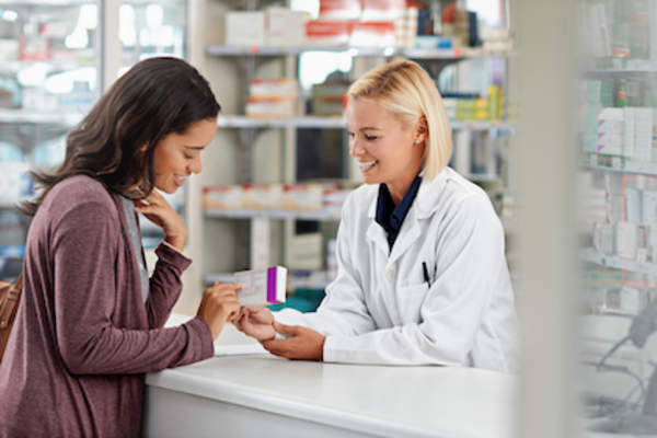 Woman picking up her prescription from a pharmacy.