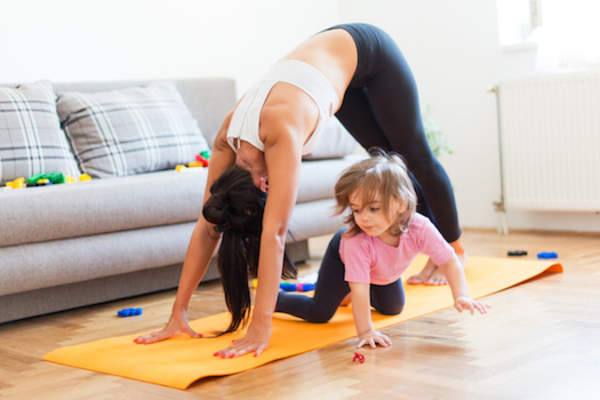 mother exercising while child plays