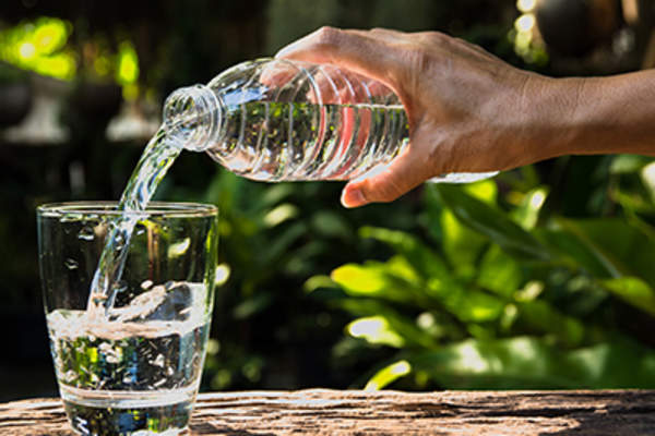 Pouring water from a bottle into a glass.