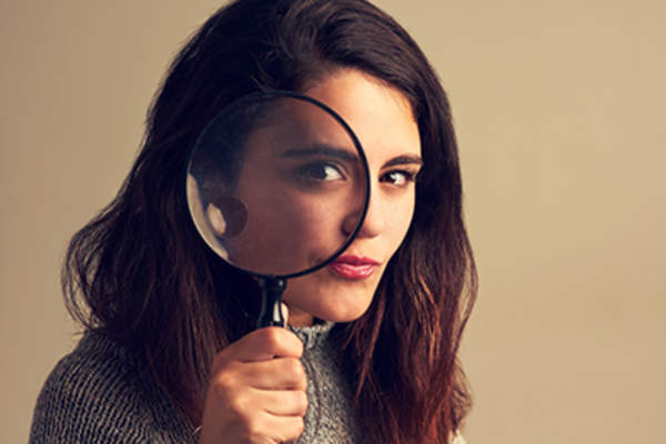 Woman holding a magnifying glass.