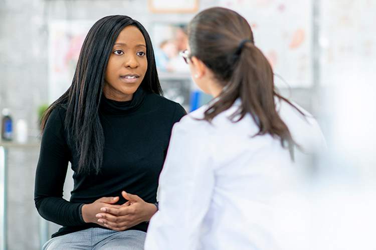 Woman discussing treatment options for IBD with her doctor.