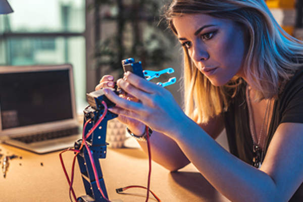 Woman scientist working on a robotic arm.