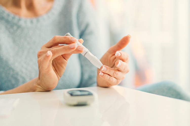 Woman performing blood glucose test.