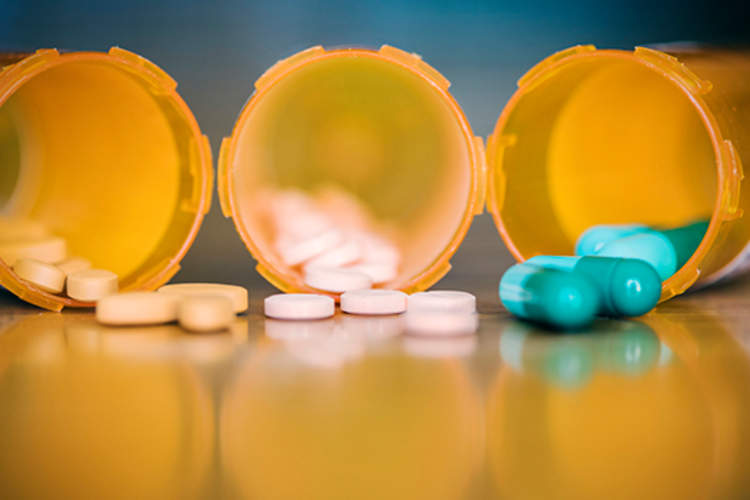 Pill bottles with medications spilling out.