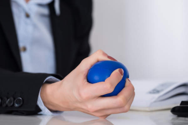 Woman squeezing stress ball.