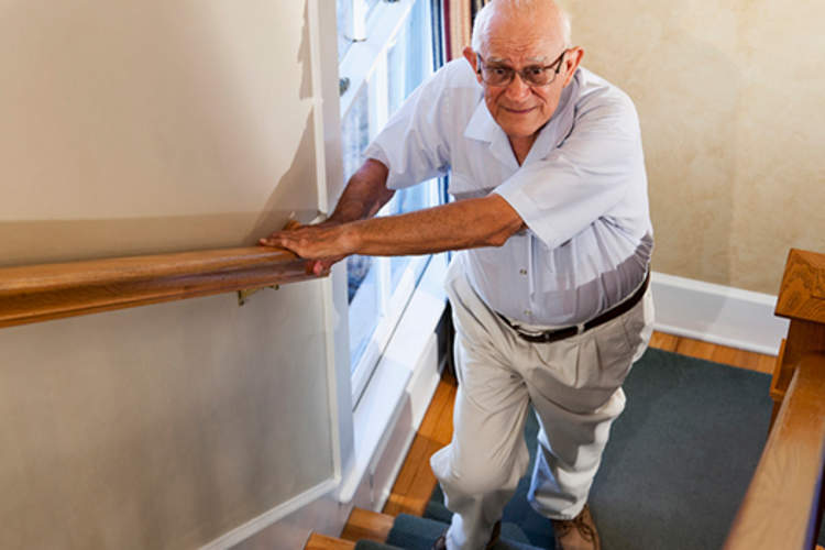 older man with leg pain walking upstairs image