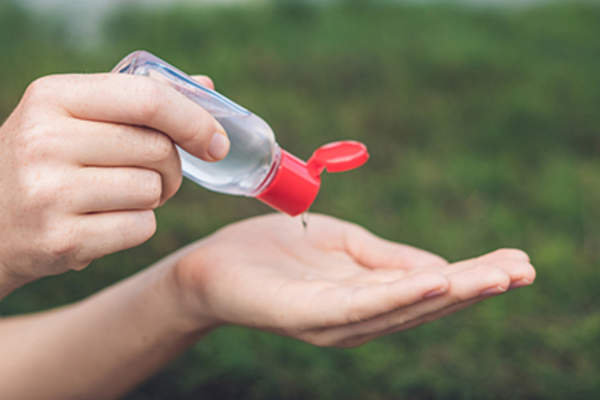 Squeezing hand sanitizer.