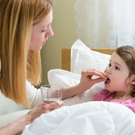 Mother giving child medicine