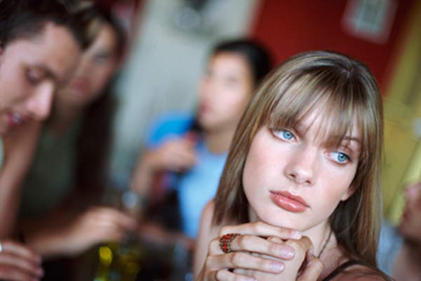 Woman feeling lonely in a group of people.