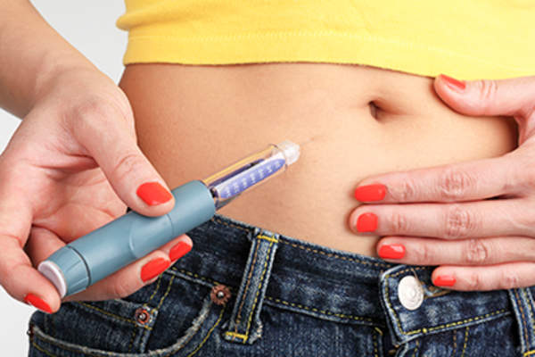 Woman self-injection in stomach.