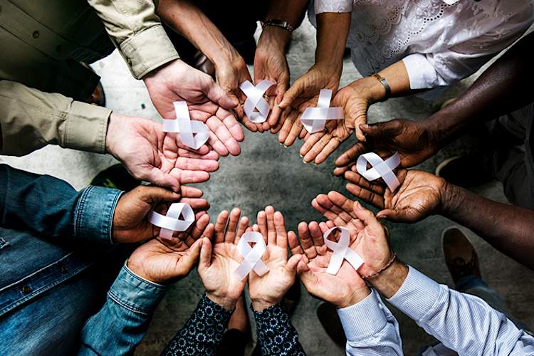 A circle of hands holding out lung cancer awareness ribbons.