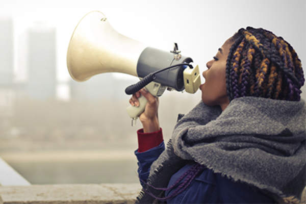 Woman talking in megaphone to raise awareness.