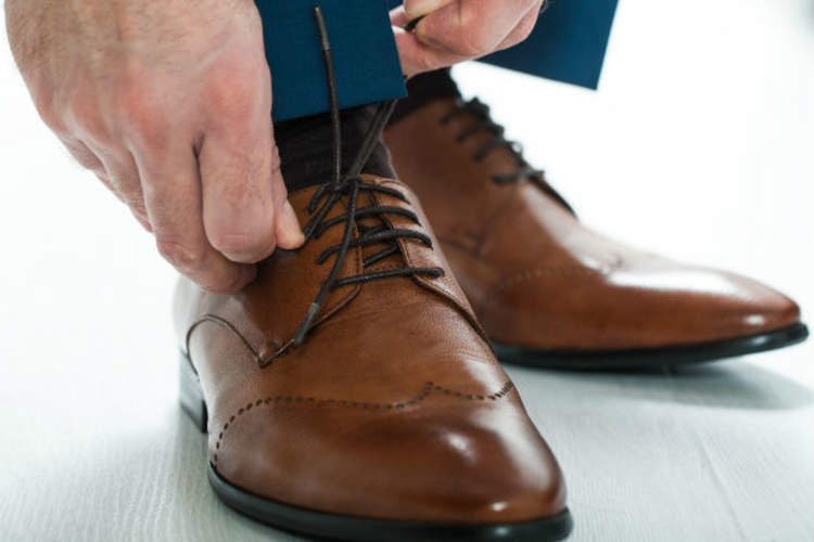 A man puts on shoes with gel insoles for his knee pain.
