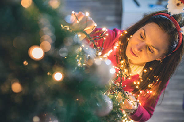 Woman hanging Christmas lights.