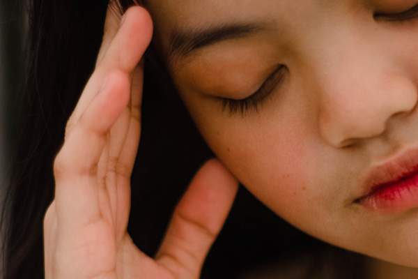 woman with headache touching head