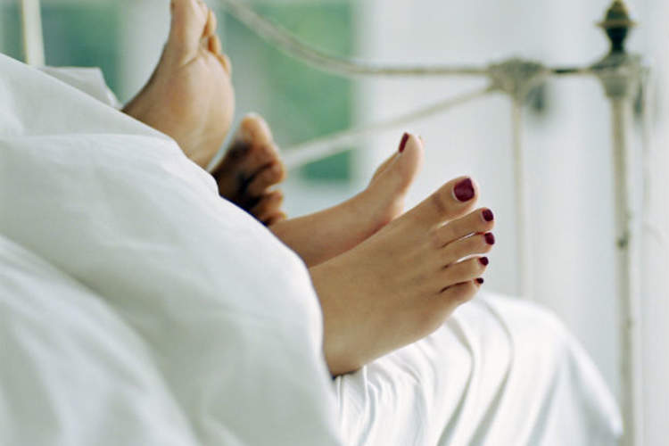 couples feet sticking out from end of bed
