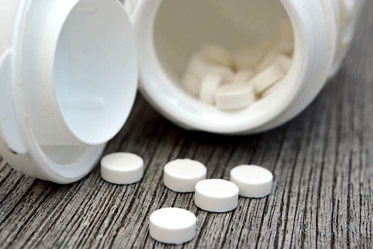 Bottle of melatonin pills spilling out.