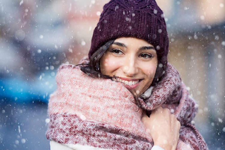 Woman smiling while bundled up in the snow.