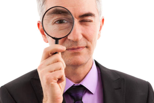 Searching concept man holding up magnifying glass.