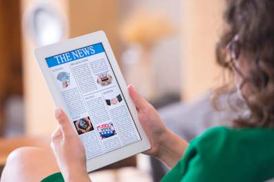 Woman reading news on tablet.