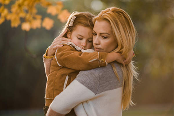 Mother and daughter hugging in the park.
