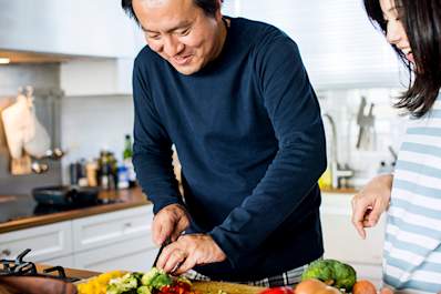 Couple making dinner together in kitchen at home.
