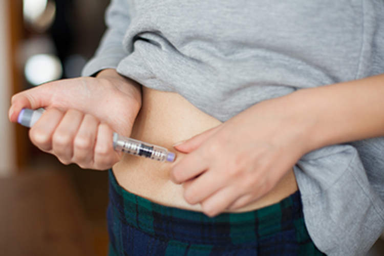 Diabetes patient administering an insulin injection.