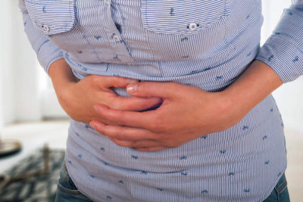 woman holding stomach.