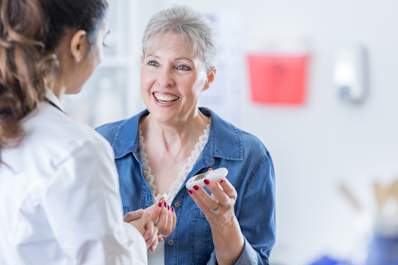 Patient talking about glucose monitor with doctor.