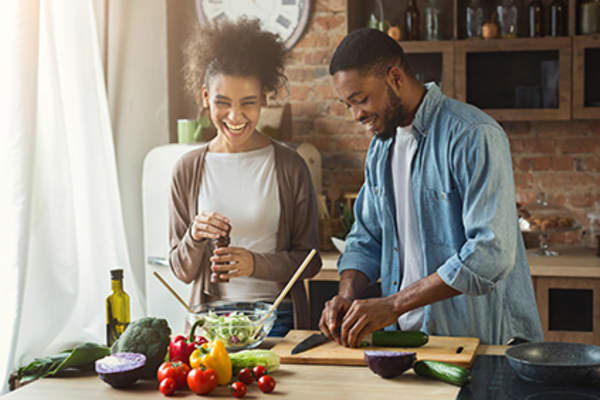 Couple making a salad together.
