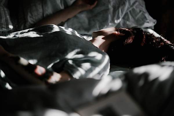 Woman lying in bed in the dark