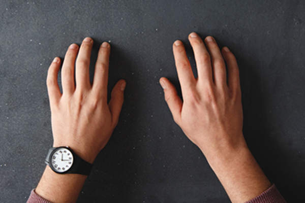 Hands on a black desk.