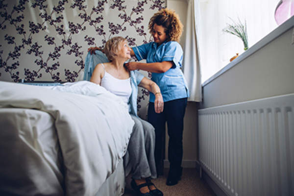 Health care worker helping senior woman.