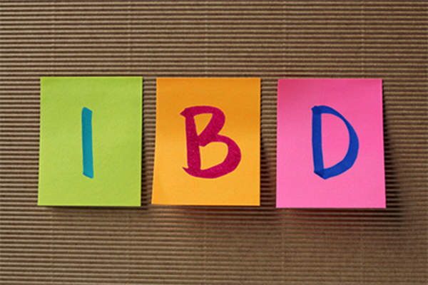 Letters IBD on colorful sticky notes on board.