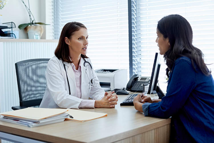 Doctor talking with a female patient in clinic.