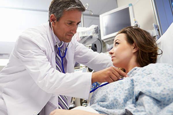 Emergency room doctor examining woman.