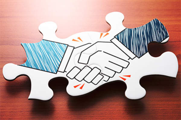 Handshake on puzzle pieces.