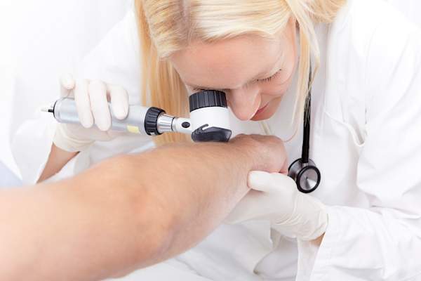 Dermatologist performing skin check.