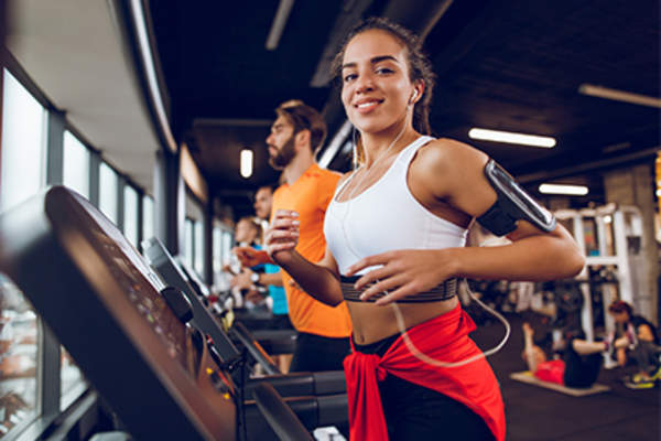 Young woman running on treadmill.