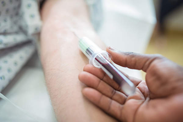 Doctor collecting blood sample from a patient.