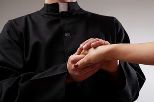 Priest comforting a woman.