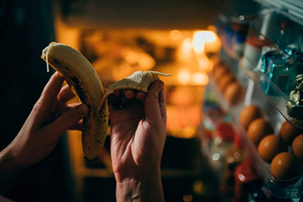 Unpeeling a banana at night.