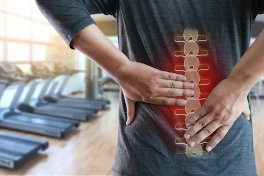 Person grabbing low back, highlighted spine and red glow indicating pain.