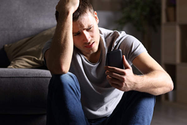 Distressed man looking at his phone.